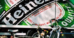 Bicycle resting by a Heineken billboard - photo via Flickr:DainoFl